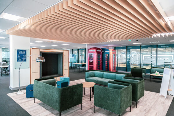 view of agile working area with wooden slatted ceiling and colourful phone booths in background